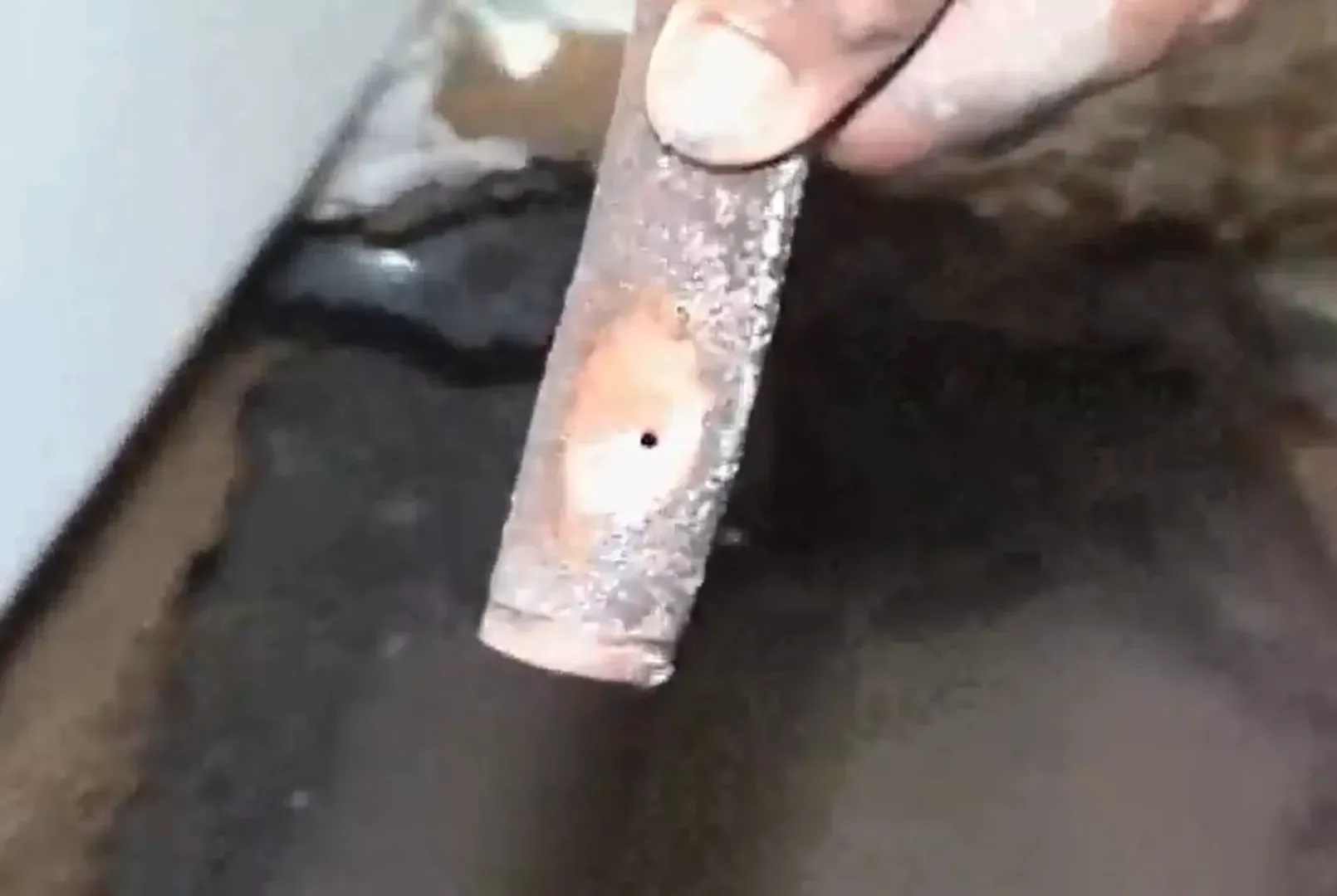 Close-up of a pinhole leak in a copper slab water line